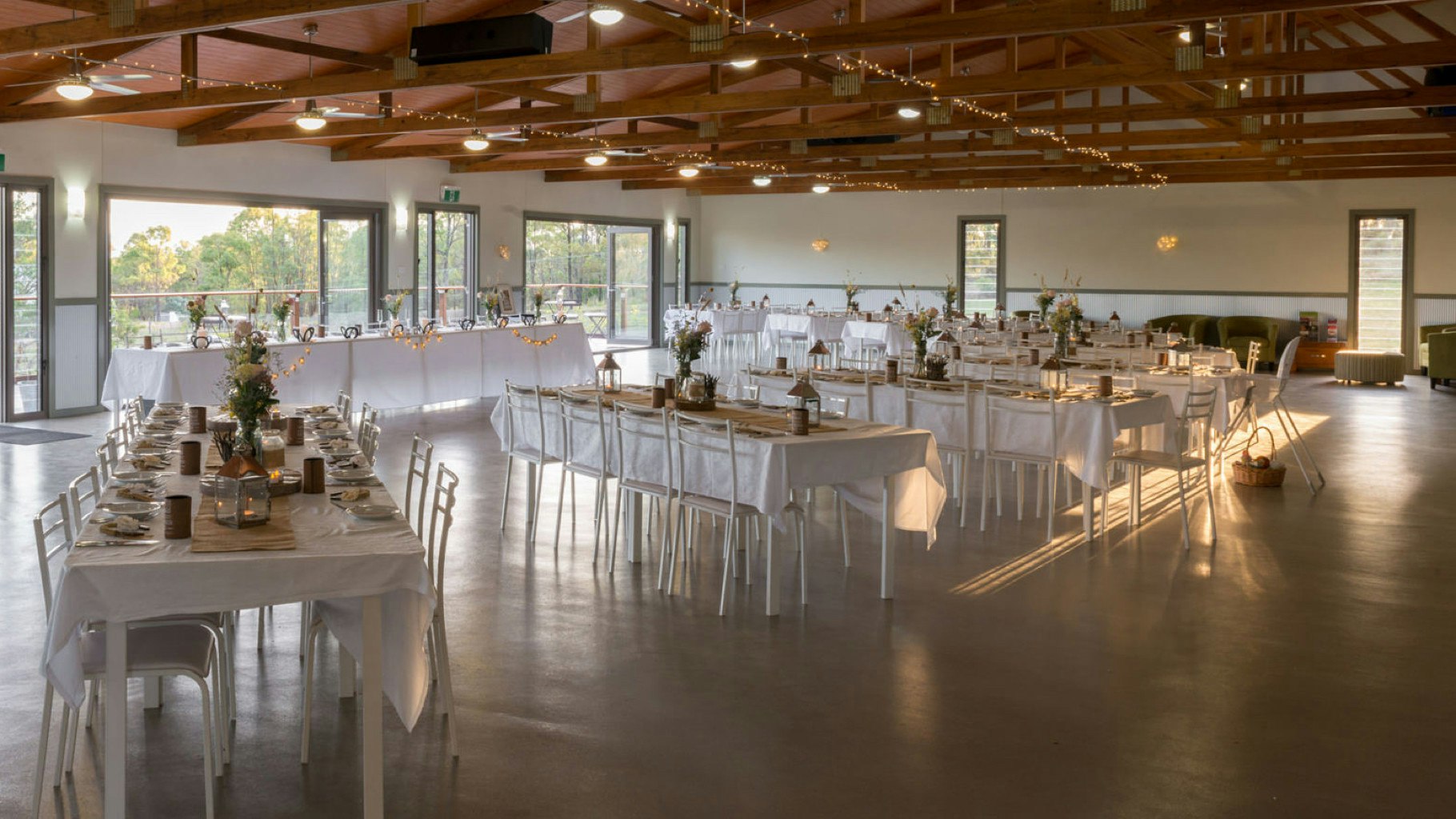 Inside a reception centre with tables set for a wedding.